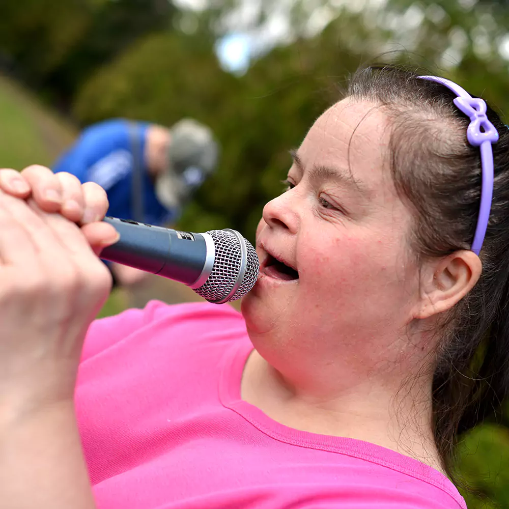 A down syndrome woman doing karaoke