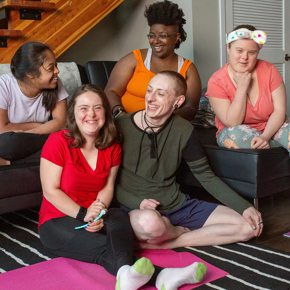 A group of friends smiling and laughing indoors